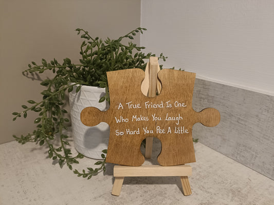 A true friend is one who makes you laugh so hard you pee a little. Jigsaw piece with display easel